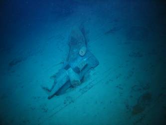 Stbd anchor embedded in steel plate from ship's side in debris field
